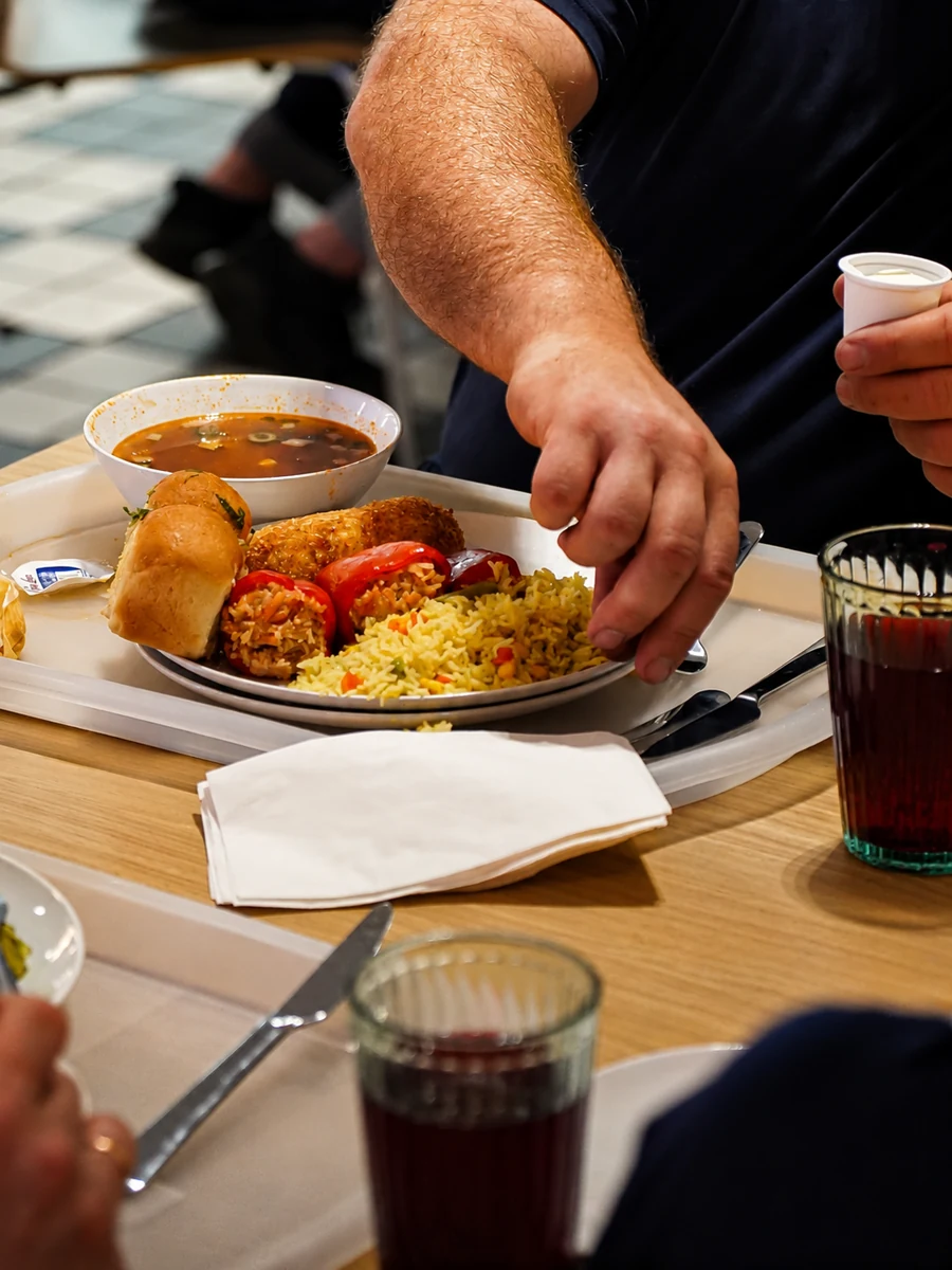 A diner serving a plate with soup, stuffed peppers, and rice at Borsch House